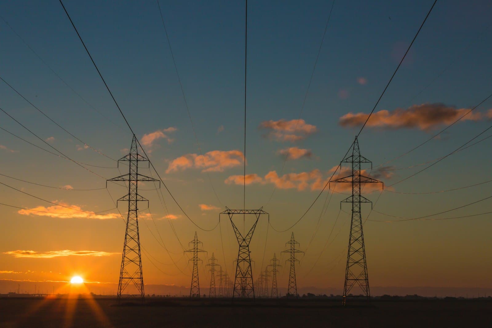 Power pylons against a sunset sky